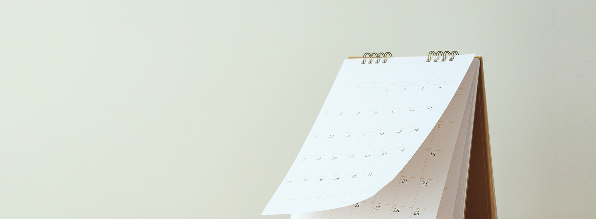 An image showing a calendar with dates spanning from December 2022 through January 2023, displayed on a white surface against a beige wall.