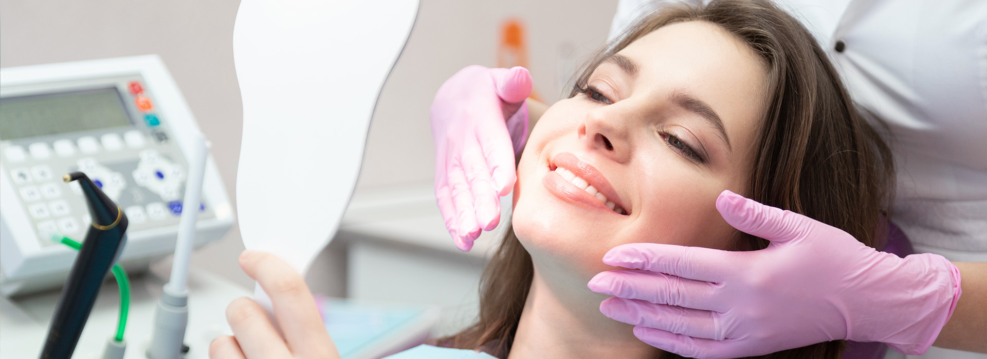 The image shows a woman receiving dental care from a professional in an office setting.