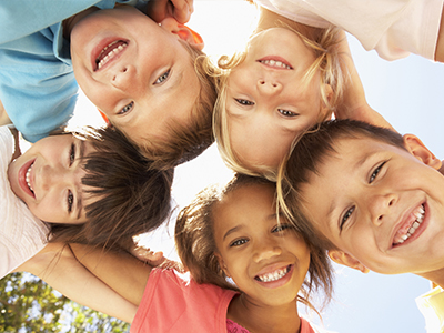 A group of children with various expressions and ages, posing together for a photo.